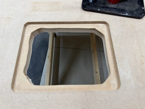 Cutout for router lift on a workbench surface, showing the surrounding wood and inner construction.